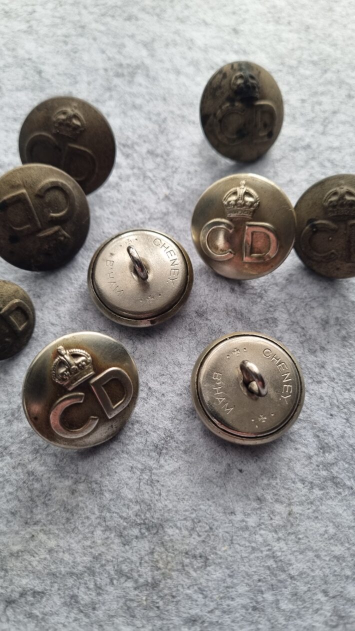 Several metal buttons bearing the letter CD and the Kings Crown taken from a Civil Defence overcoat